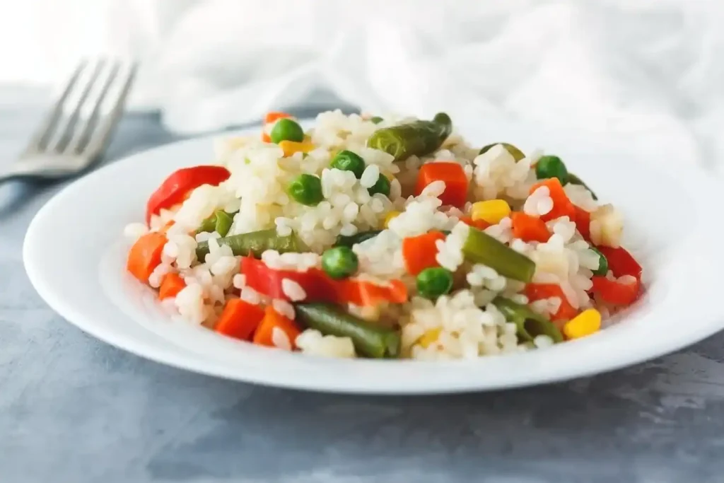 Arroz com vegetais, opção de acompanhamento para almoço de Páscoa Arroz com vegetais coloridos servido como acompanhamento no almoço de Páscoa