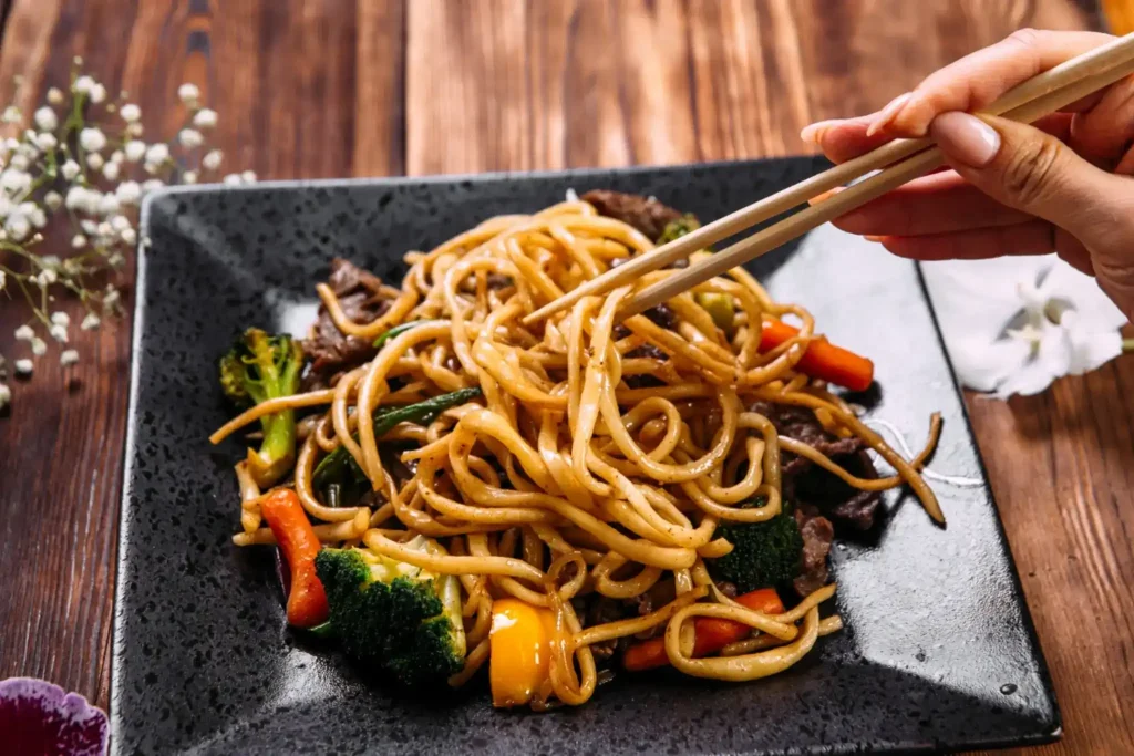Yakissoba Yakissoba com macarrão oriental, legumes coloridos e carne salteados
