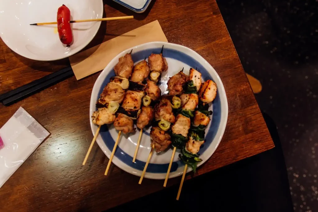 Yakitori Yakitori, com espetinhos de frango dourados e legumes.