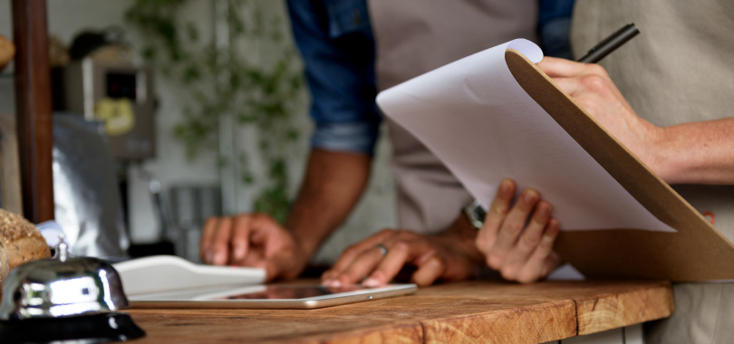 Aprenda a fazer um planejamento mensal para seu restaurante 2 Duas pessoas anotando e se dedicando ao planejamento mensal.