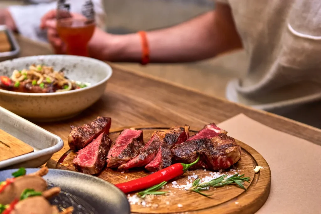 Tábua com cortes de carne grelhada e suculenta, representando algumas das melhores carnes para churrasco.