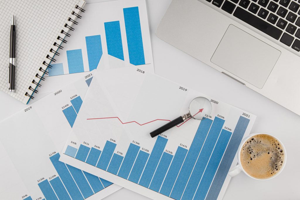 Histórico de vendas na Quaresma: como empresas de alimentação podem evitar desperdícios? 1 Gráficos de crescimento analisando histórico de vendas com laptop e documentos
Title: Análise de histórico de vendas