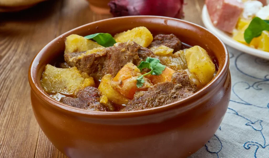 Cortes bovinos: guia com tabela, mapa e dicas de preparo 4 Ensopado de cortes bovinos com batata e cenoura servido em panela de barro rústica